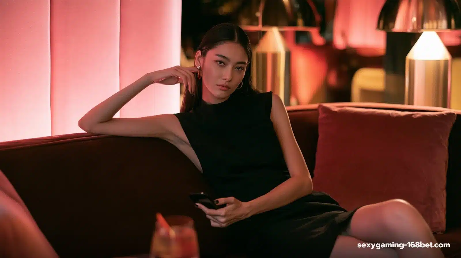 สาวไทยนั่งพักบนโซฟากำมะหยี่พร้อมสมาร์ตโฟน